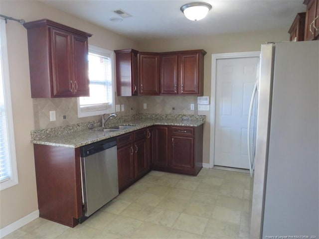 kitchen with decorative backsplash, white fridge, stainless steel dishwasher, and sink