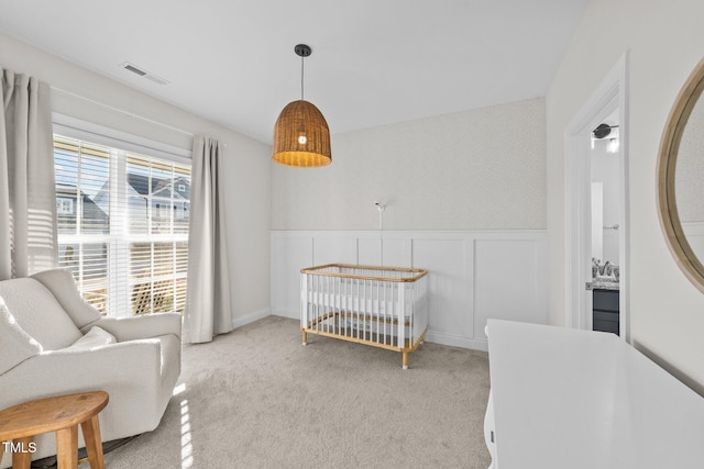 bedroom with a crib and light colored carpet