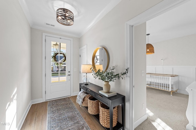 entryway with crown molding and hardwood / wood-style flooring