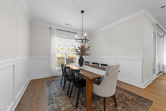 dining room featuring hardwood / wood-style floors, a notable chandelier, and ornamental molding