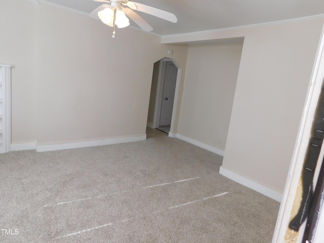 carpeted spare room featuring ceiling fan and crown molding