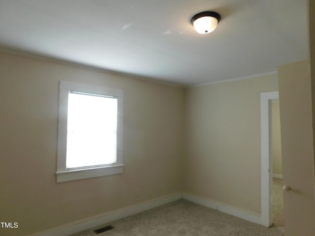 spare room featuring light carpet and crown molding