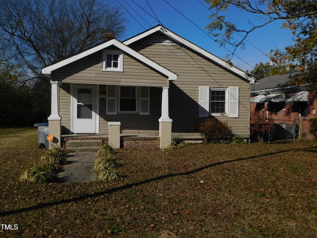 bungalow-style house with covered porch and a front lawn