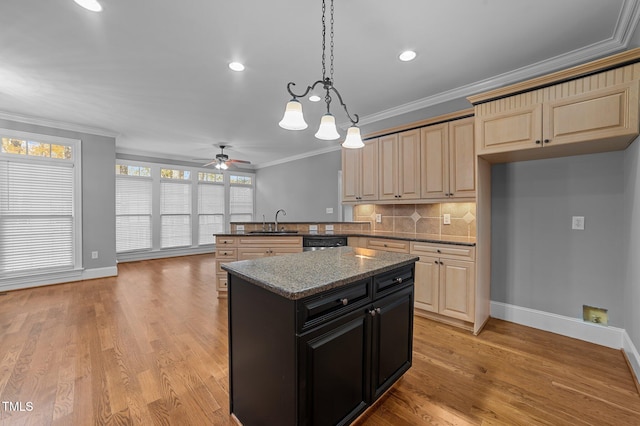 kitchen with kitchen peninsula, dark stone counters, ceiling fan, sink, and light hardwood / wood-style flooring