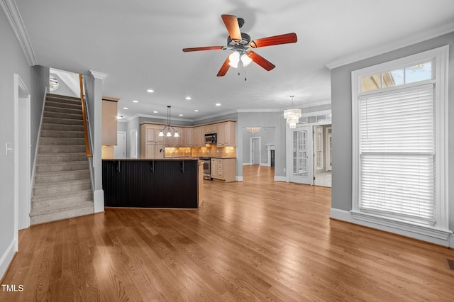 unfurnished living room with crown molding, ceiling fan with notable chandelier, and light wood-type flooring