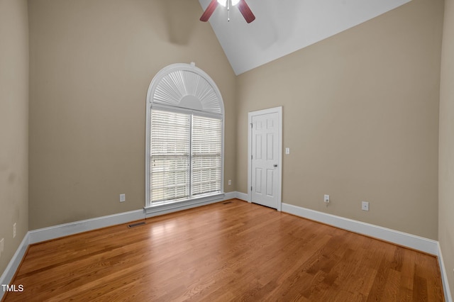 unfurnished room featuring hardwood / wood-style flooring, ceiling fan, and high vaulted ceiling