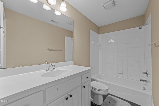 full bathroom with tile patterned floors, vanity, tiled shower / bath combo, and toilet