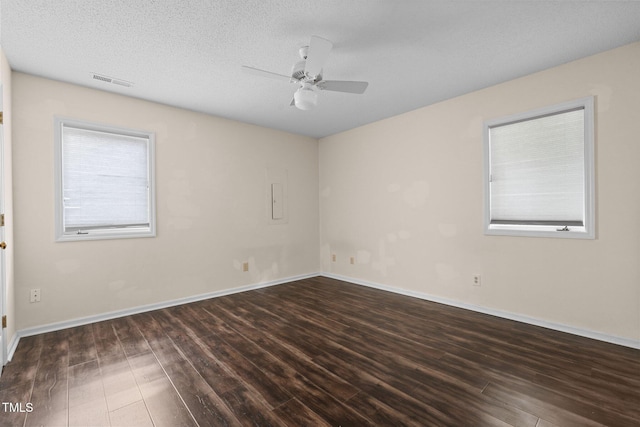 empty room with ceiling fan, dark hardwood / wood-style flooring, and a textured ceiling