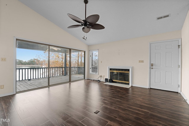 unfurnished living room with ceiling fan, plenty of natural light, high vaulted ceiling, and dark hardwood / wood-style floors