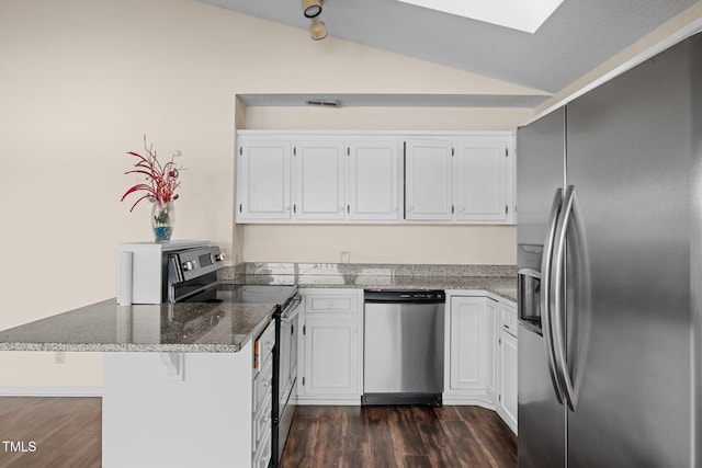 kitchen featuring white cabinets, lofted ceiling, kitchen peninsula, and stainless steel appliances