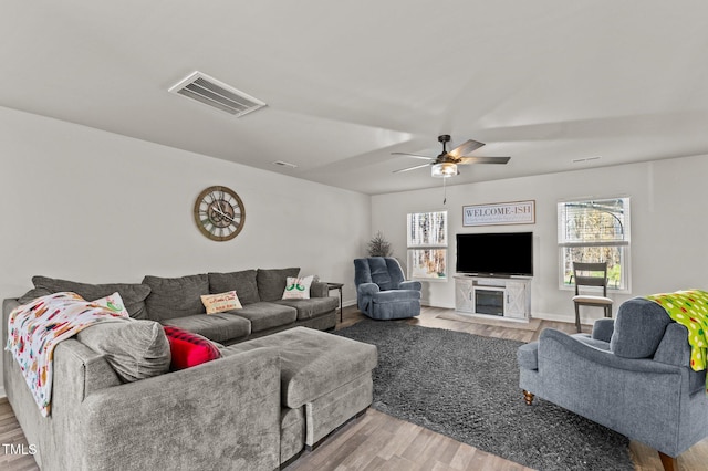 living room featuring light hardwood / wood-style floors and ceiling fan