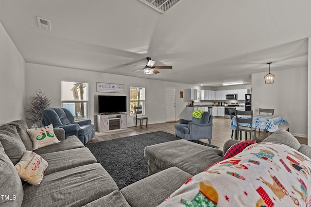 living room featuring light hardwood / wood-style flooring and ceiling fan