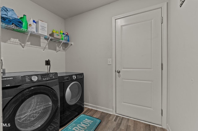 clothes washing area featuring washer and clothes dryer and dark hardwood / wood-style floors