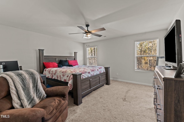 carpeted bedroom featuring multiple windows and ceiling fan