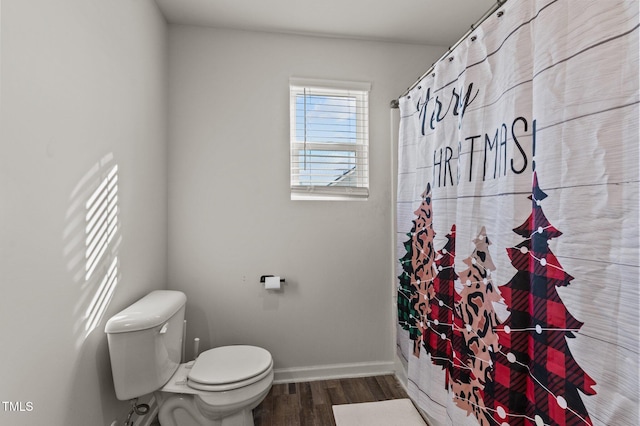 bathroom featuring wood-type flooring, toilet, and a shower with curtain