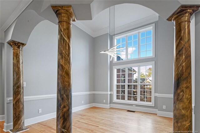 363 Kimberwicke Dr, Fayetteville, NC 28311 - unfurnished dining area featuring decorative columns, light wood-style flooring, ornamental molding, and baseboards
