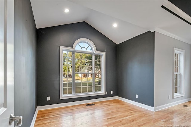 empty room with light hardwood / wood-style flooring and lofted ceiling