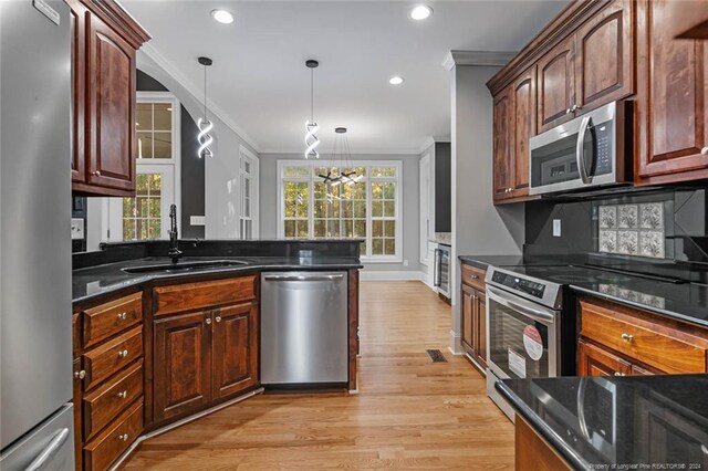 363 Kimberwicke Dr, Fayetteville, NC 28311 - kitchen with appliances with stainless steel finishes, ornamental molding, a sink, light wood finished floors, and dark stone countertops