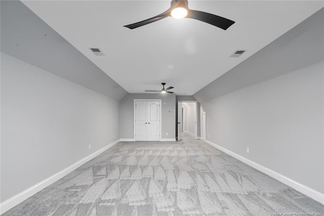 additional living space featuring light colored carpet, ceiling fan, and lofted ceiling