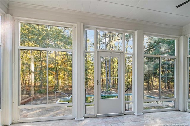 doorway to outside with crown molding and plenty of natural light
