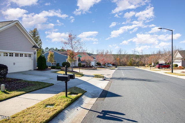 view of street with street lights, curbs, sidewalks, and a residential view