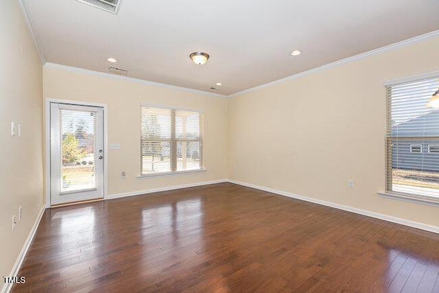 empty room featuring baseboards, dark wood finished floors, visible vents, and crown molding