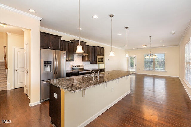 kitchen with a kitchen bar, hanging light fixtures, dark brown cabinets, dark hardwood / wood-style flooring, and stainless steel appliances