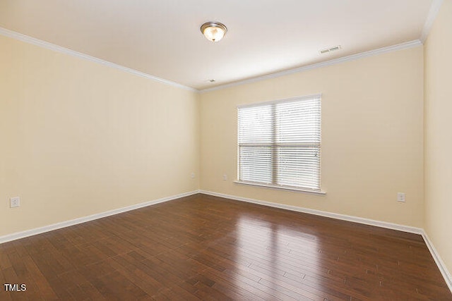 empty room with baseboards, crown molding, visible vents, and dark wood-style flooring