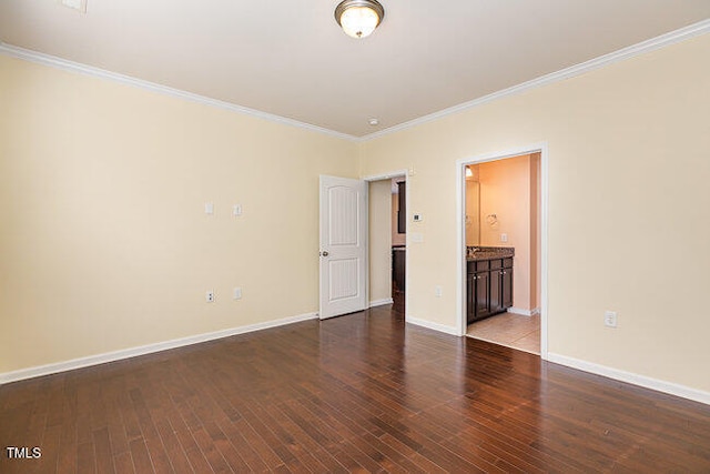 unfurnished room with crown molding, wood finished floors, and baseboards