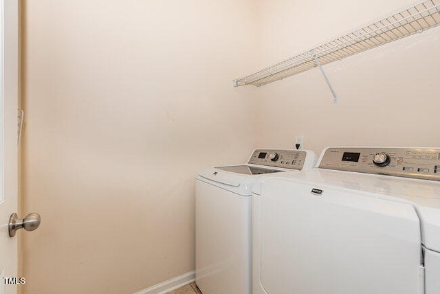 laundry room featuring laundry area, baseboards, and separate washer and dryer