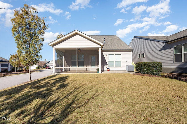 view of front of property featuring a front yard, a sunroom, and central air condition unit