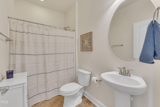 bathroom featuring tile patterned flooring, toilet, sink, and walk in shower