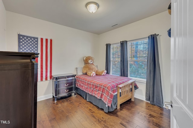 bedroom with dark hardwood / wood-style floors