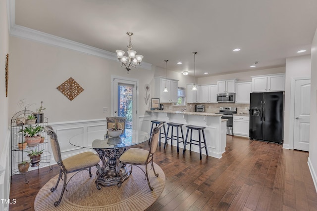 dining area featuring a notable chandelier, ornamental molding, and dark wood-type flooring