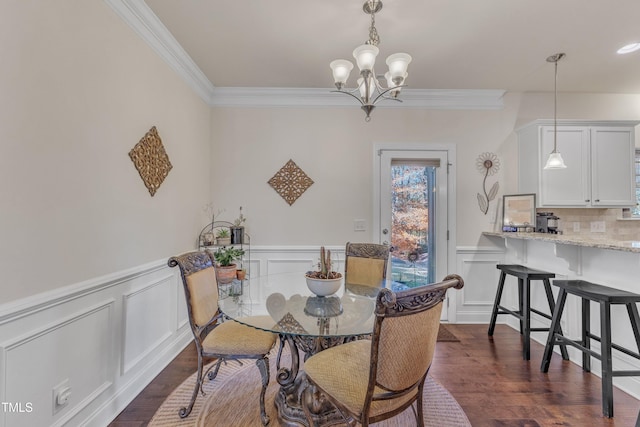 dining room with crown molding, dark wood-type flooring, and a chandelier