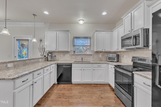 kitchen with pendant lighting, white cabinets, and stainless steel appliances