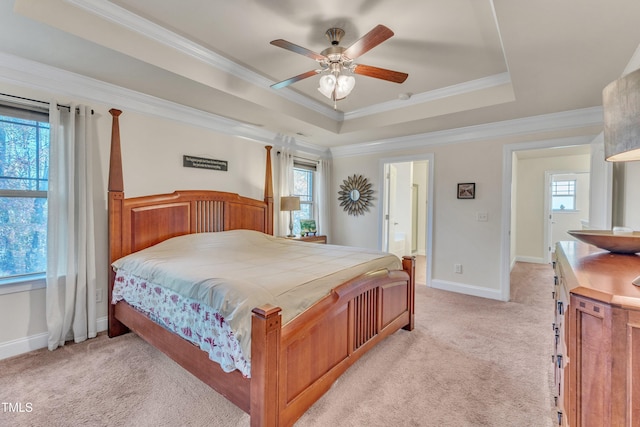 bedroom featuring ceiling fan, a tray ceiling, and multiple windows