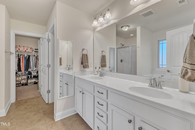 bathroom with tile patterned flooring, vanity, and a shower with door