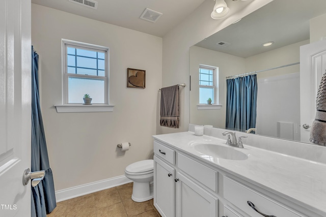 bathroom with toilet, plenty of natural light, vanity, and tile patterned flooring