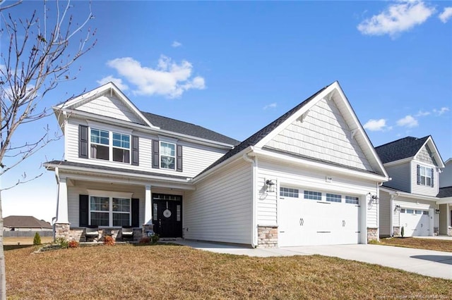 craftsman-style house with covered porch, a garage, and a front yard