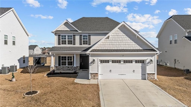 craftsman inspired home with a garage and central AC unit