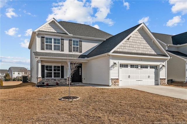 craftsman inspired home with a garage, a front yard, and central AC