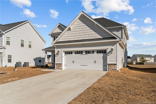 view of front of house featuring a front yard, central AC, and a garage