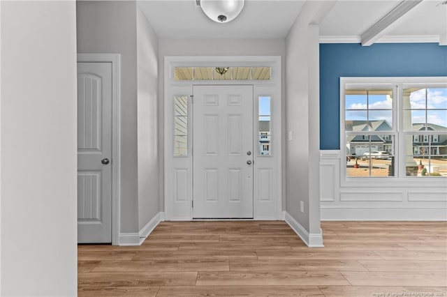 entrance foyer with crown molding and light hardwood / wood-style flooring