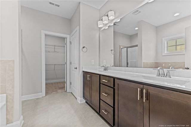 bathroom featuring tile patterned floors, an enclosed shower, and vanity