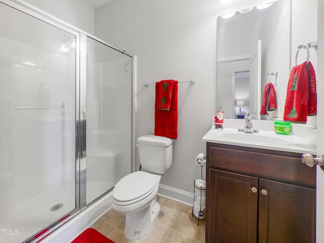 bathroom with tile patterned floors, vanity, toilet, and a shower with door