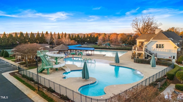 view of pool featuring a playground and a water slide