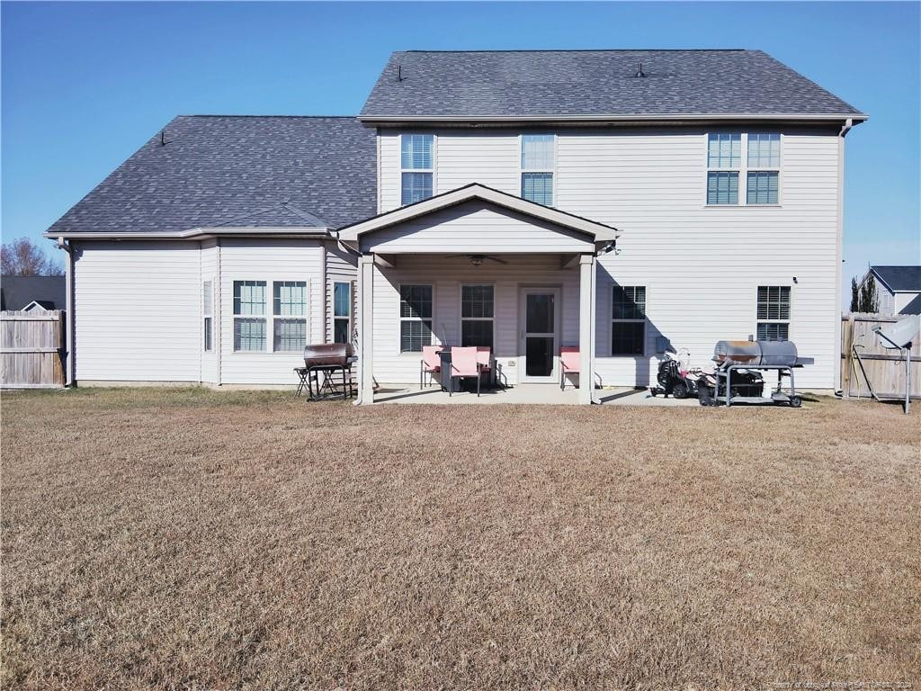 back of house with ceiling fan, a yard, and a patio