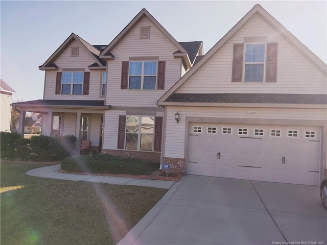 view of front of home featuring a garage, driveway, brick siding, and a front lawn