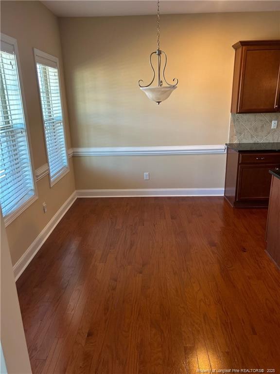 6605 Stillwood Dr, Hope Mills, NC 28348 - unfurnished dining area with dark wood-style floors and baseboards